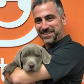 Alex Samios Holding Puppy