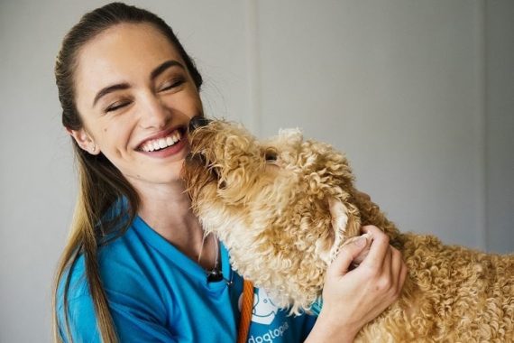 Happy dog loves kissing team member