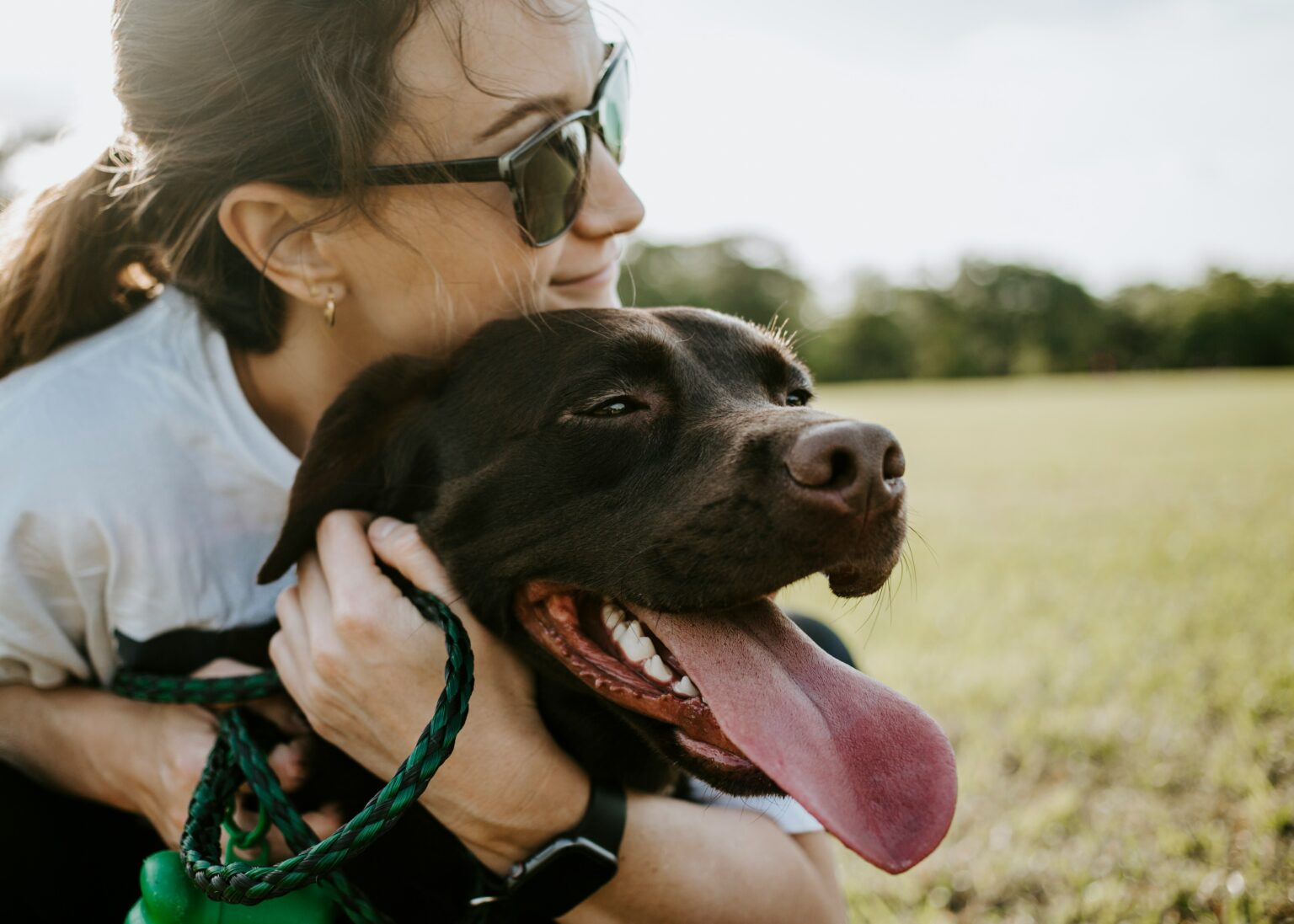 A dog mom hugging her dog
