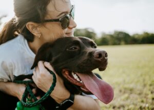 A dog mom hugging her dog