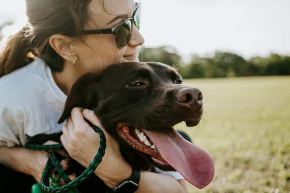 A dog mom hugging her dog