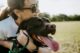 A dog mom hugging her dog
