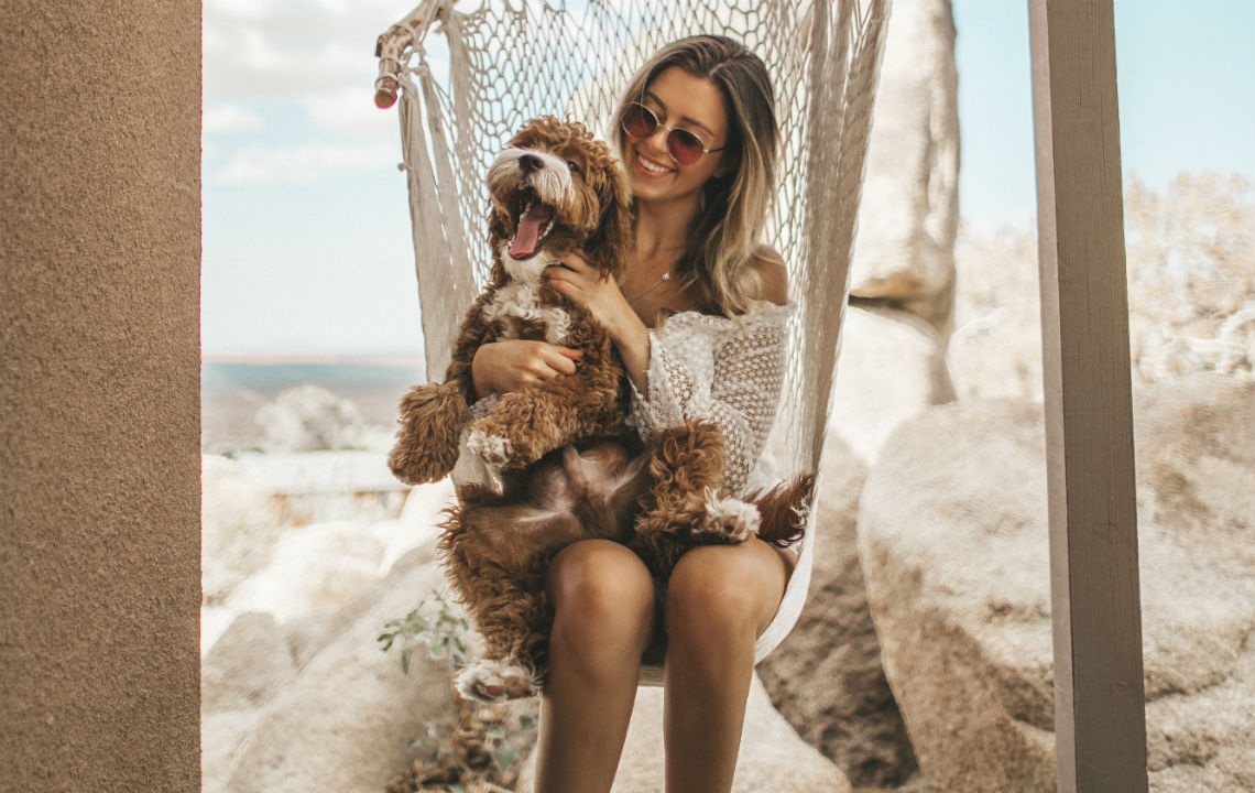 Woman holding dog in hammock chair