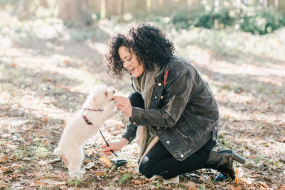 Woman feeding small dog a treat