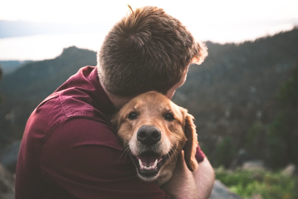 A dog dad hugging his dog outside