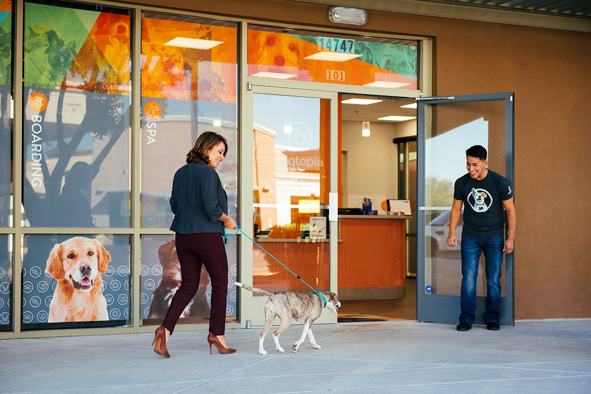 Woman coming into the Dogtopia center with her dog