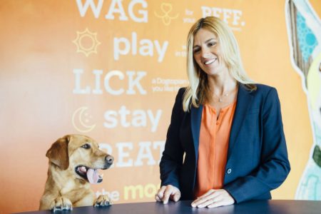 Owner dropping-off a dog at Dogtopia of Roswell reception desk.