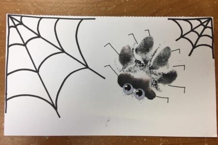 A Halloween craft using a dog paw print to look like a spider that will be offered at Dogtopia of Summerville dog daycare.